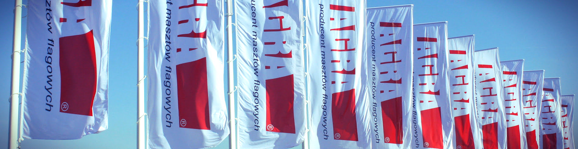 Długi rząd Masztów Flagowych z Flagami z napisem "Agra Producent Masztów Flagowych"
